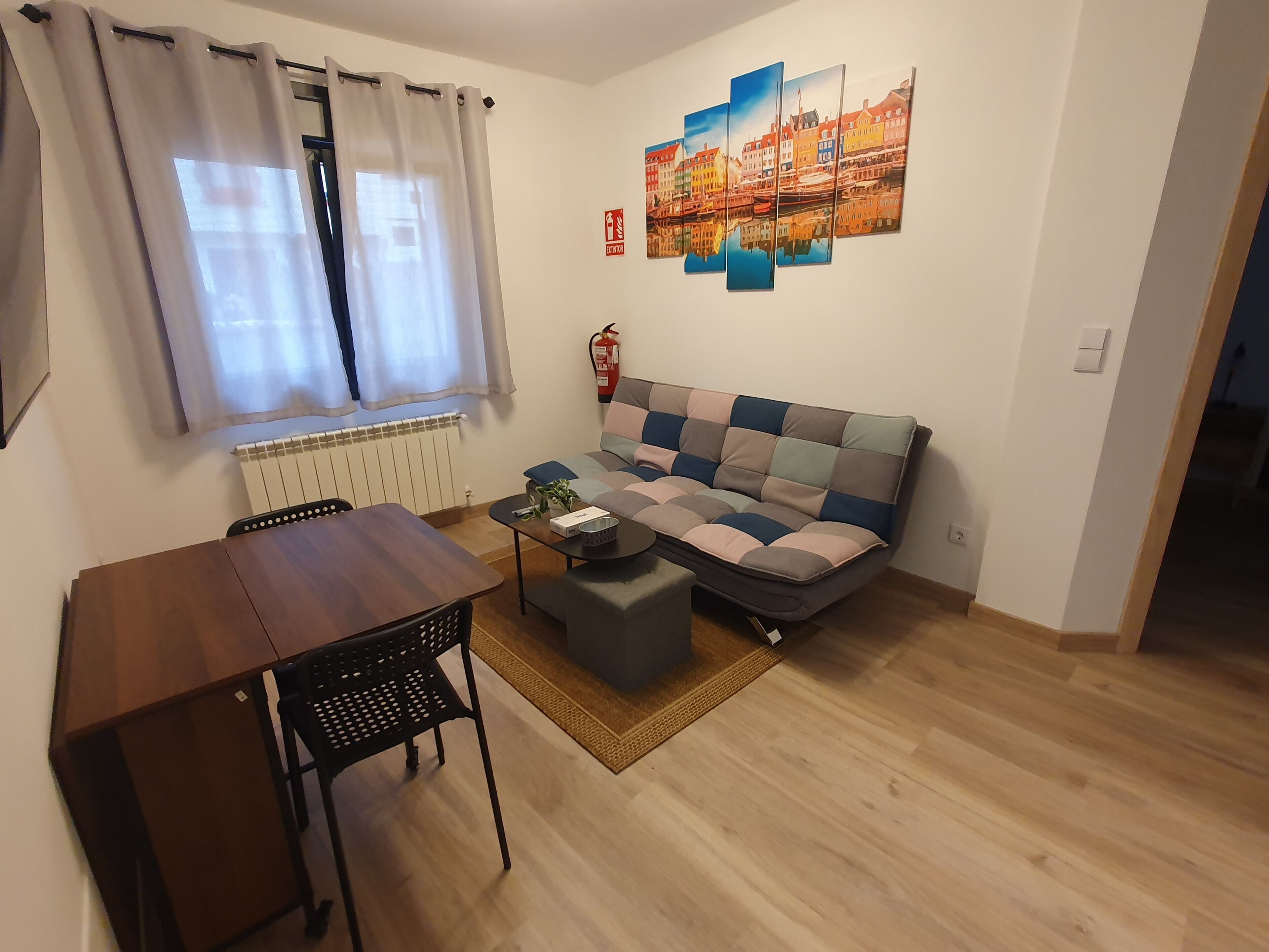 Ein Wohnzimmer mit einer Couch, einem Couchtisch, einem Esstisch und einem Sessel.