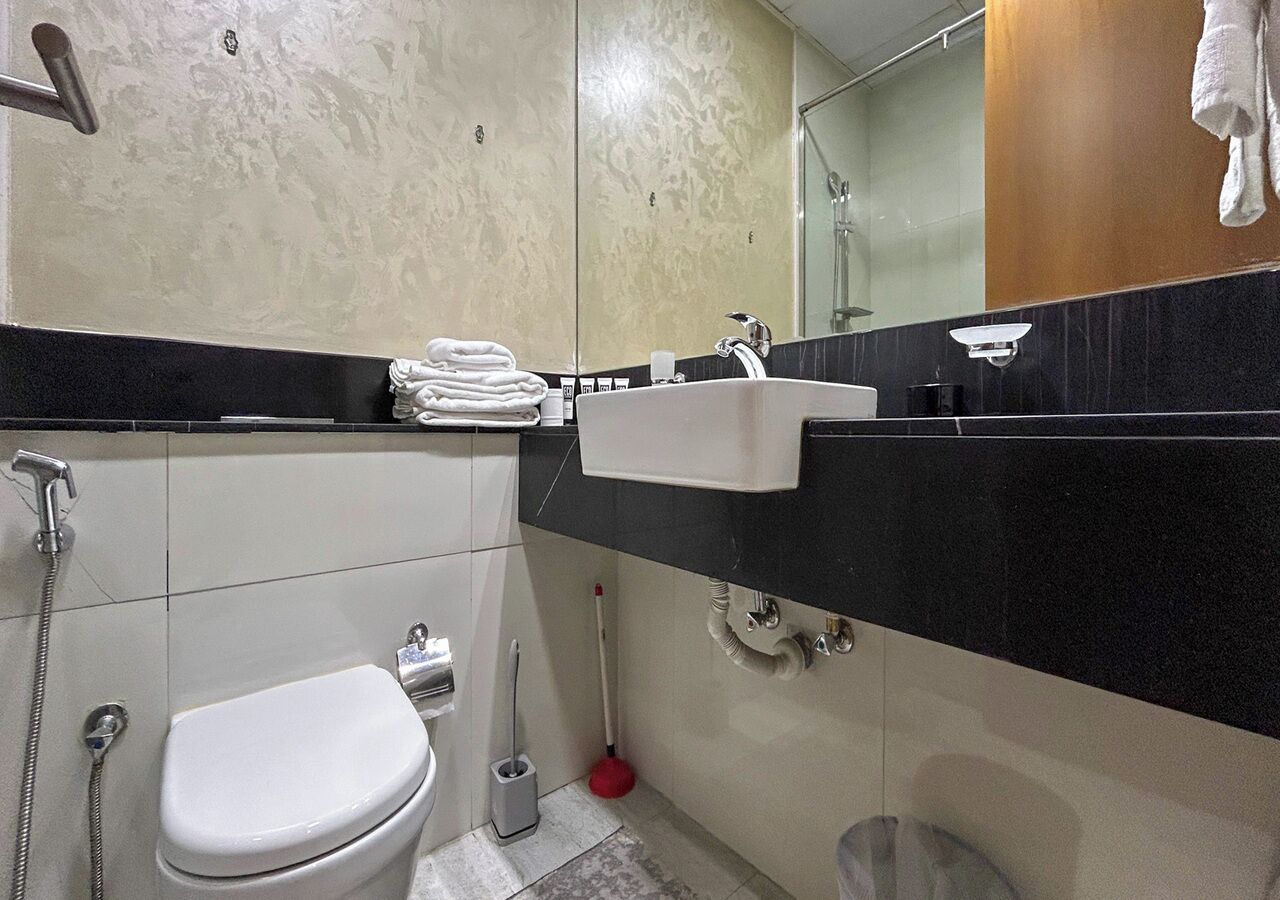 Une salle de bain avec des toilettes, un lavabo et une douche.