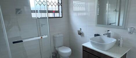 Een douche, handdoeken, toiletpapier