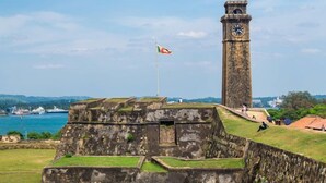 Un fort historique doté d’une tour horlogée, d’un drapeau et offrant une vue sur la mer.