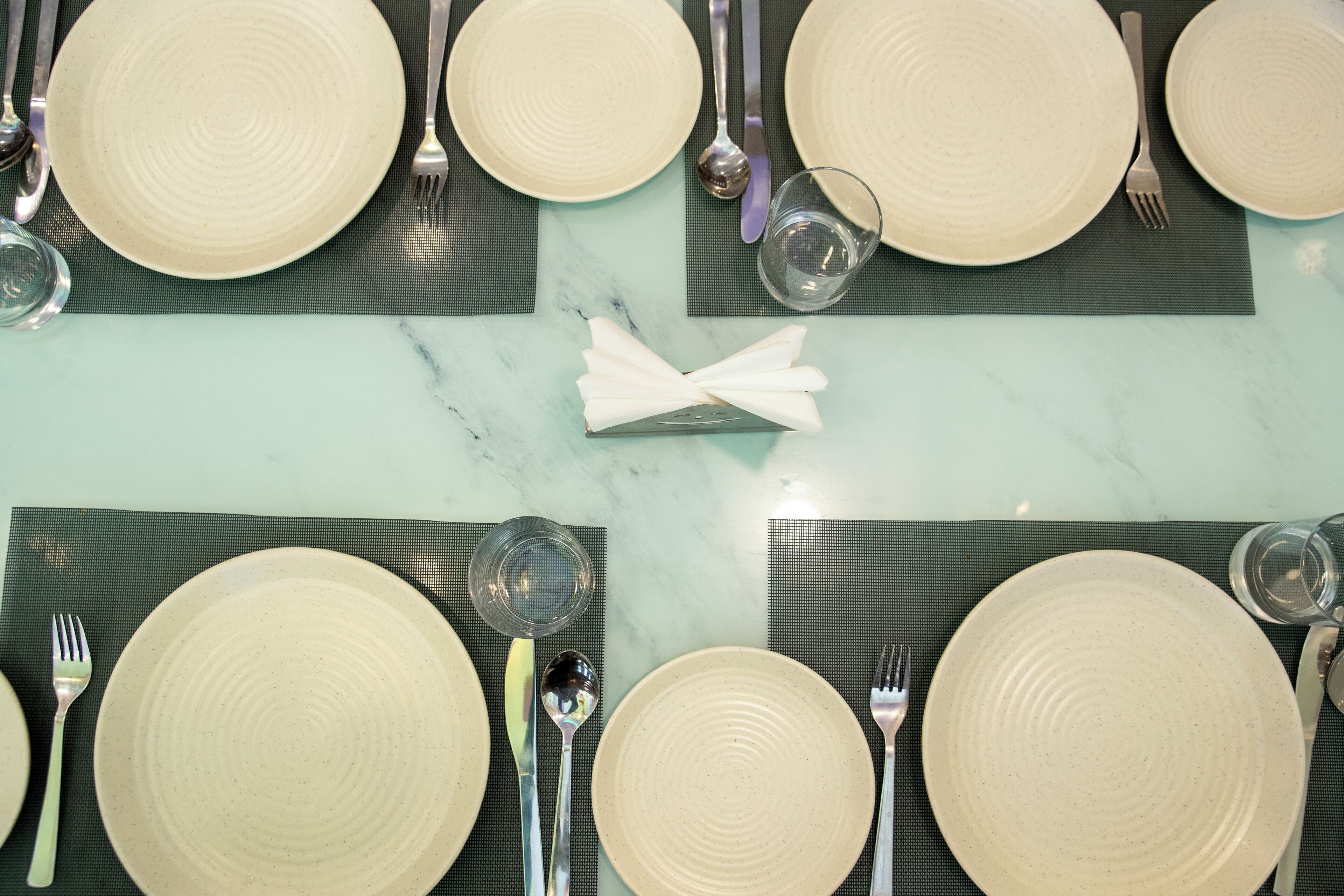 A table set with plates, cutlery, and a folded napkin.