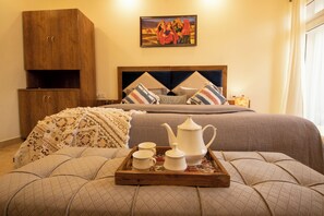 A neatly arranged bedroom with a bed, a wooden wardrobe, a bedside table with a tray of tea set, and a painting on the wall. - Perfectstayz Hills Rishikesh (Rishikesh)