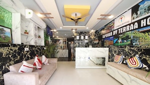 A hotel reception area with marble walls, a reception desk, and seating areas. - Perfectstayz Hills Rishikesh (Rishikesh)