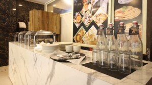 A breakfast buffet with various food items, clear glass bottles, and a wooden cabinet. - Perfectstayz Hills Rishikesh (Rishikesh)