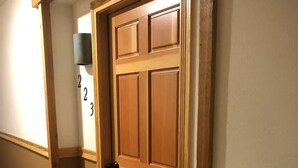A wooden door with a black handle, a carpeted floor, and a wall-mounted light fixture. - Cozy 1-bedroom condo in charming Driggs with WiFi (Driggs)