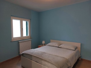 A bedroom with a bed, a window, a nightstand, and a lamp. - Entire Villa (Ravello)