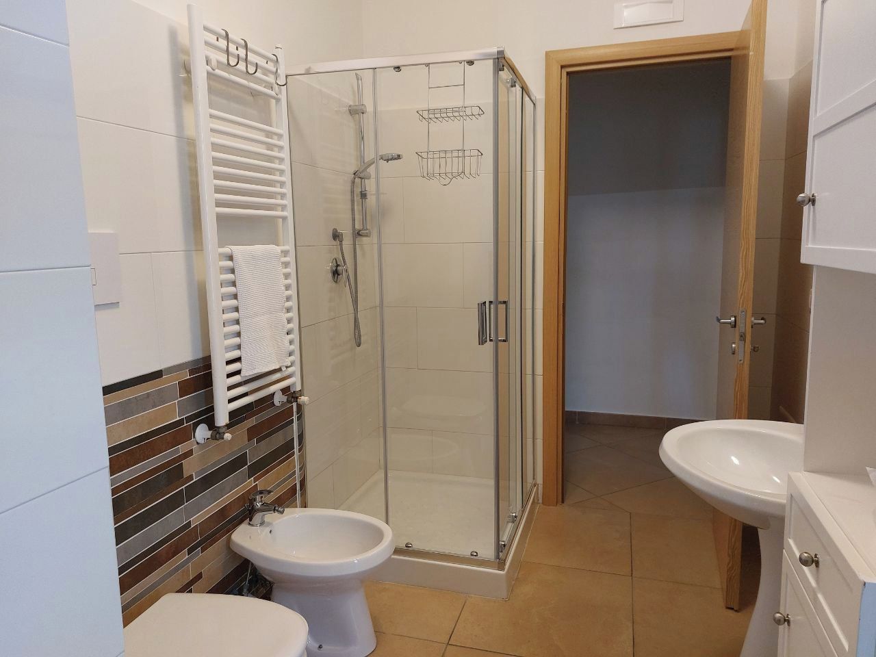 Un bagno con doccia, toilette e lavandino.