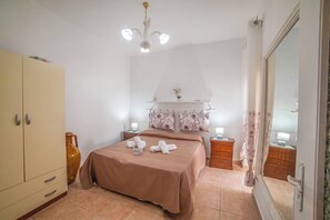 A bedroom with a bed, bedside tables, a wardrobe, and a mirror. - Rusciu Te Lu Mare Apartment With Terrace & Garden (Porto Cesareo)