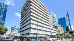 A multi-story hotel with a modern architectural design, featuring a prominent corner location with clear views of the surrounding cityscape.