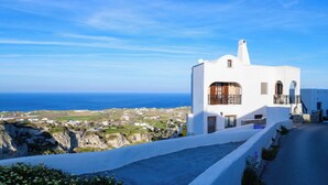 A white building with a balcony, a view of the sea, and a clear sky. - Casa della Liberta Firostefani (Santorini)