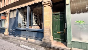A building facade with a green door, large windows, and a sign for 'SRI LANKAN INDIAN RESTAURANT'. - 2 Bedroom Queen Street (Newcastle-upon-Tyne)