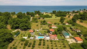 An aerial view of a coastal residential area with houses, a swimming pool, and a clear view of the sea. - Alba Marea (Dio-Olympos)