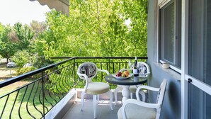 A balcony with a table, chairs, and a view of greenery. - Alba Marea (Dio-Olympos)