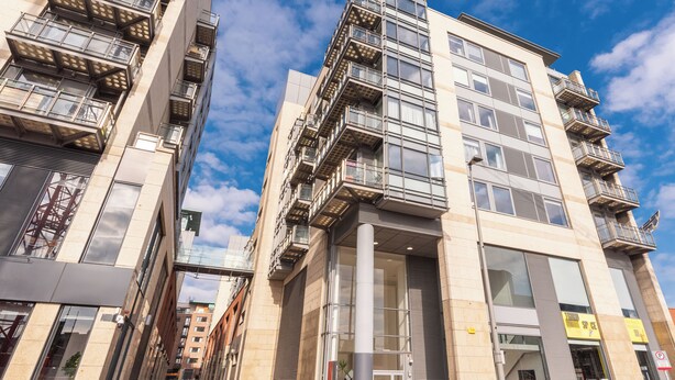 A modern high-rise building with multiple balconies and large windows. - 2-bedroom apartment in charming Smithfield Market with Parking (Dublin)
