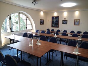 A conference room with long tables, chairs, and artwork on the walls. - Modern vacation rental on a country estate with a large garden, plenty of nature, a courtyard garden, and a lake (Kehnert)