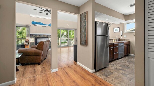 A modern kitchen with a stainless steel refrigerator, wooden cabinets, and a large window. - Quiet Waterfront Getaway in North Ocean City (Ocean City)