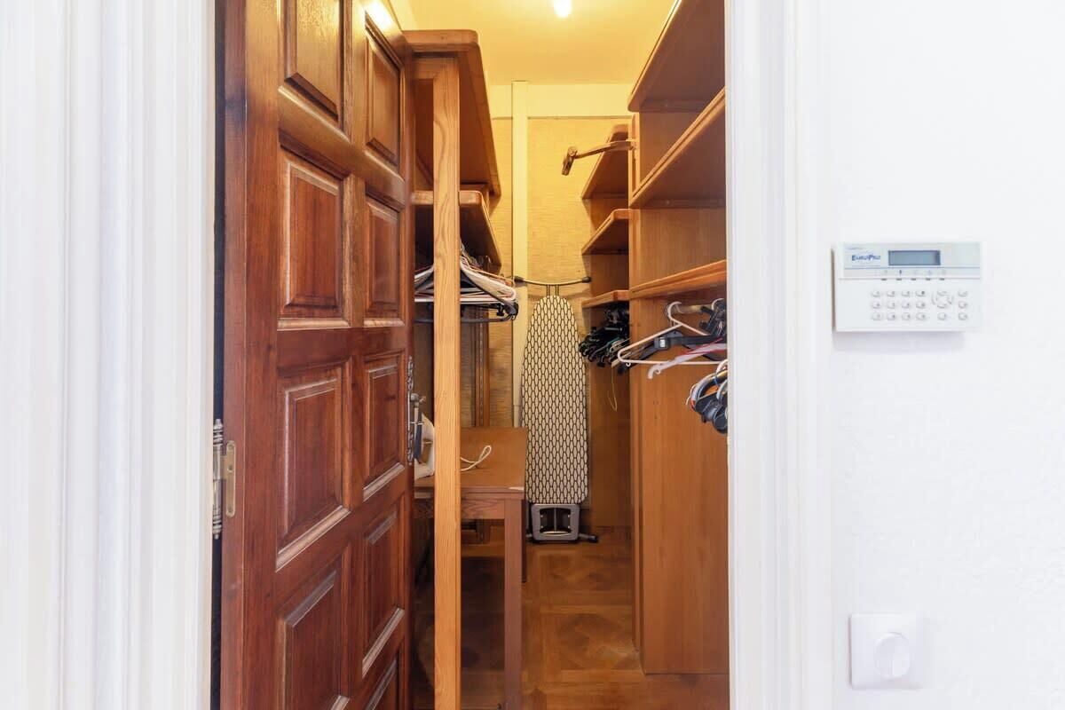Un couloir étroit avec des portes en bois et un placard intégré.