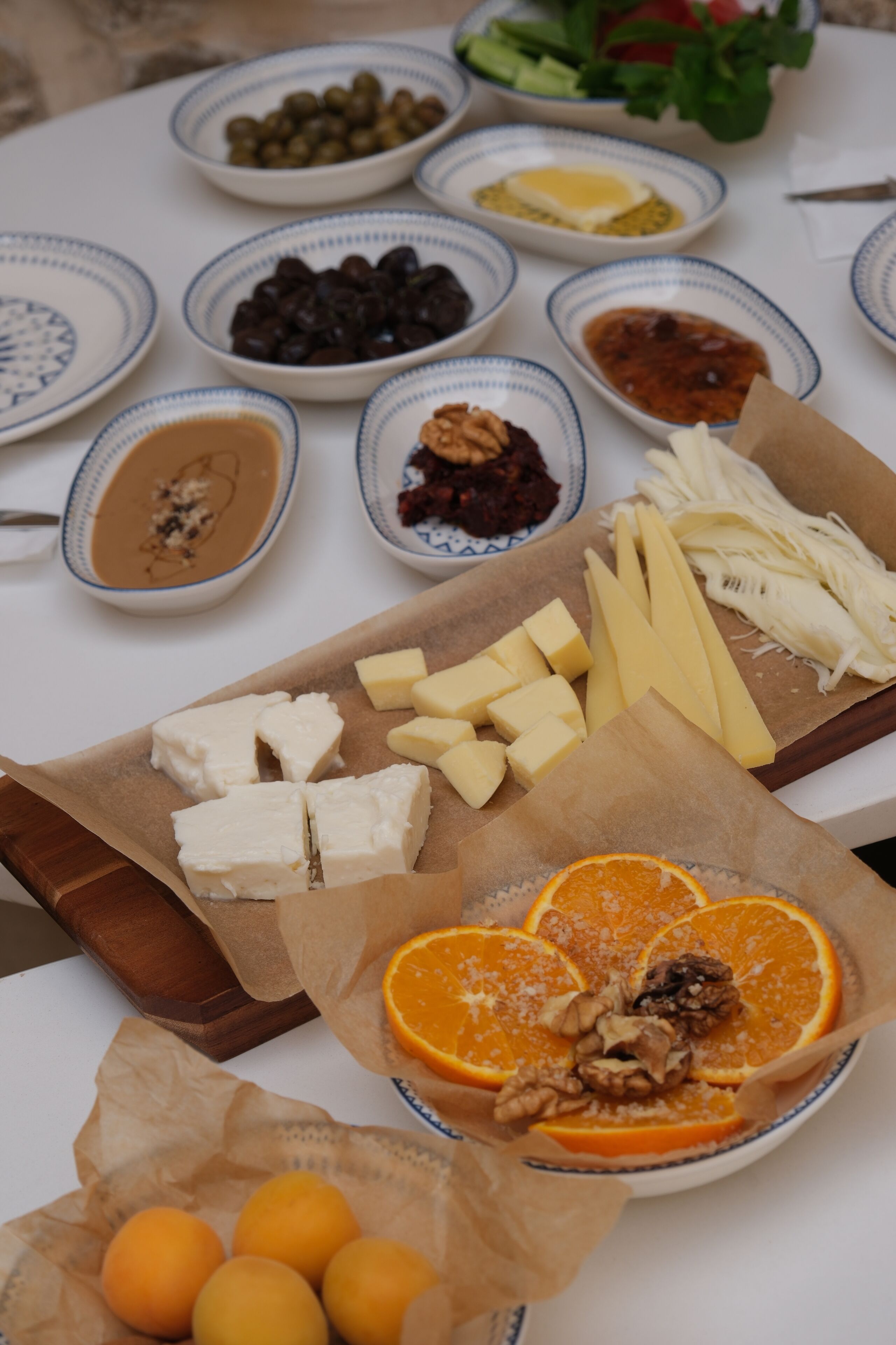 A table with various food items including cheeses, fruits, and nuts.