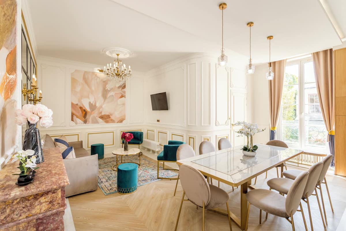A spacious dining area with a large table, comfortable seating, and a chandelier.