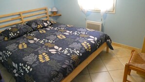 A bedroom with a bed, a nightstand, a lamp, and a chair. - GITE MURIER WITH POOL AND RIVER (Berrias-et-Casteljau)