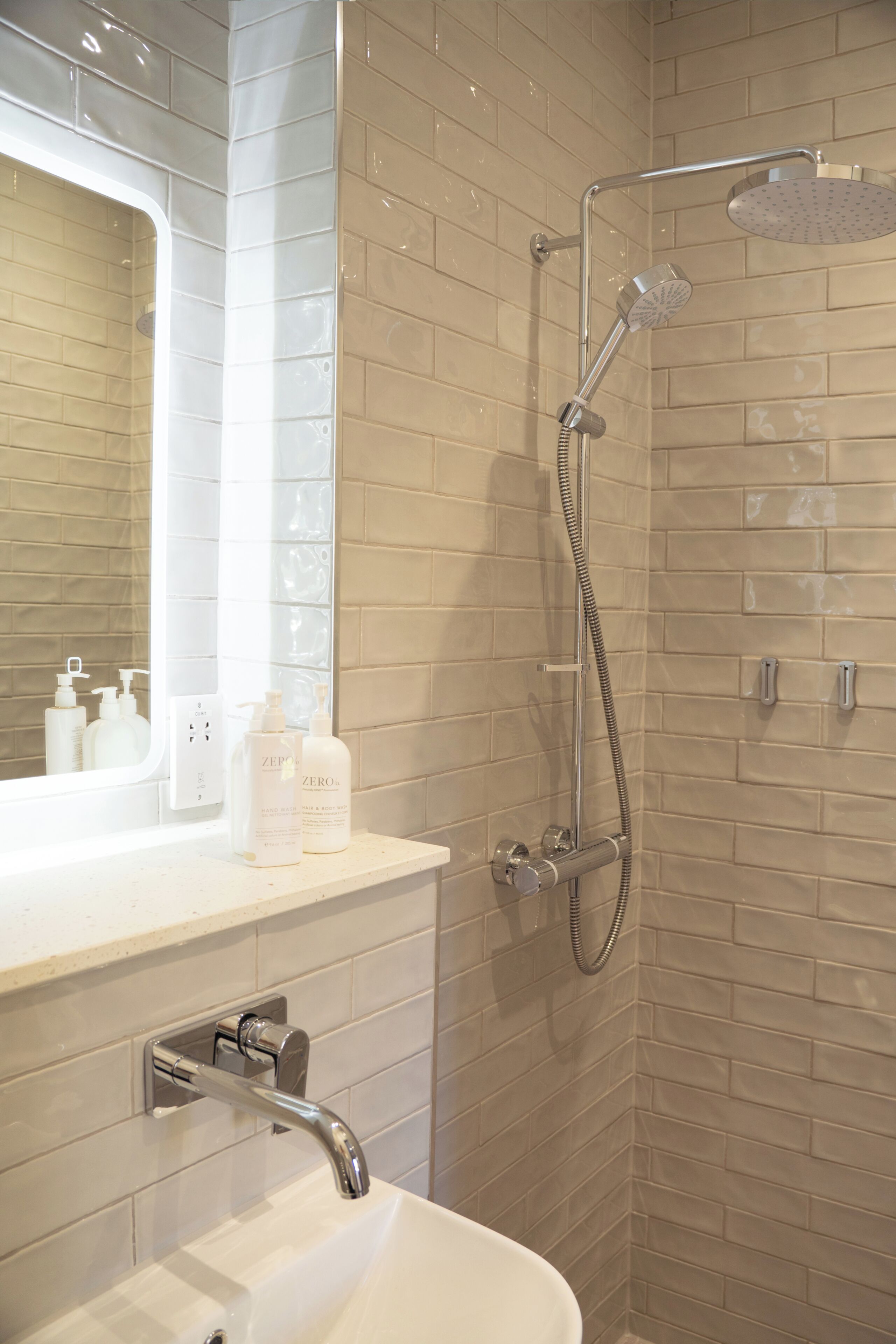 A bathroom with a shower, a sink, and a mirror.