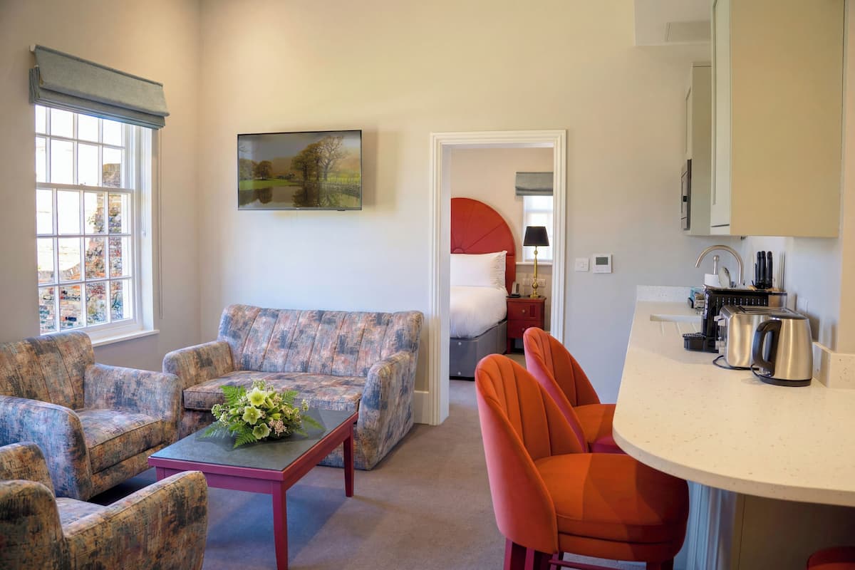 A living room with a sofa, chairs, a coffee table, and a dining area with a table and chairs.