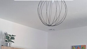 Una cocina moderna con armarios de madera, una encimera negra y un reloj rojo.