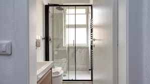A modern bathroom with a glass-enclosed shower, a toilet, and a towel rack. - Stylish Studios near Subway (Milan)