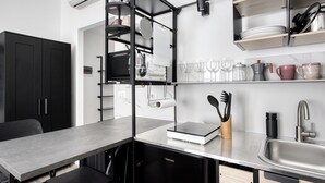 A modern kitchen with a built-in dishwasher, a sink, and a countertop with a coffee maker and utensils. - Stylish Studios near Subway (Milan)