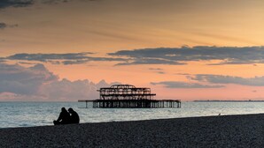 Une plage avec une jetée en arrière-plan.