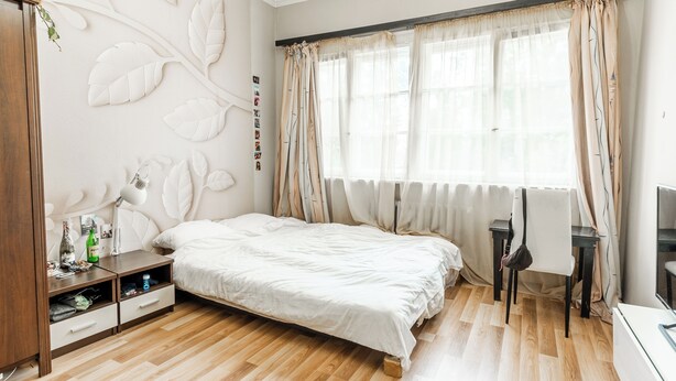 Un dormitorio con una cama, un escritorio y una silla.
