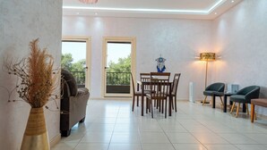 Una sala moderna con sofá, mesa de comedor, sillas y una lámpara de pie.