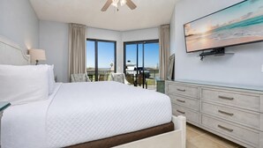 Une chambre avec un grand lit, une télévision et un balcon offrant une vue agréable.