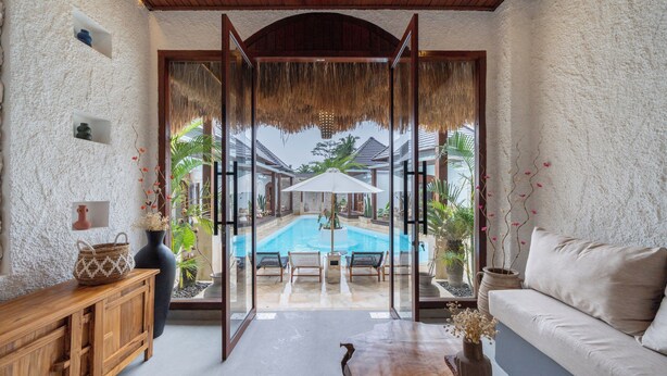A room with a view of a pool, a wooden bench, a sofa, and a cabinet. - Casa Maddu (Sebatu)