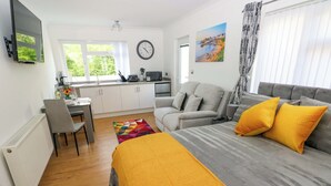 Un dormitorio moderno con cama, sofá, zona de comedor y cocina.