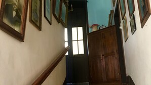 A staircase with multiple framed pictures on the walls, leading to a door with a window. - Bed and breakfast in Castelfranc, ideal for a cycling stopover in the Lot valley (Castelfranc)