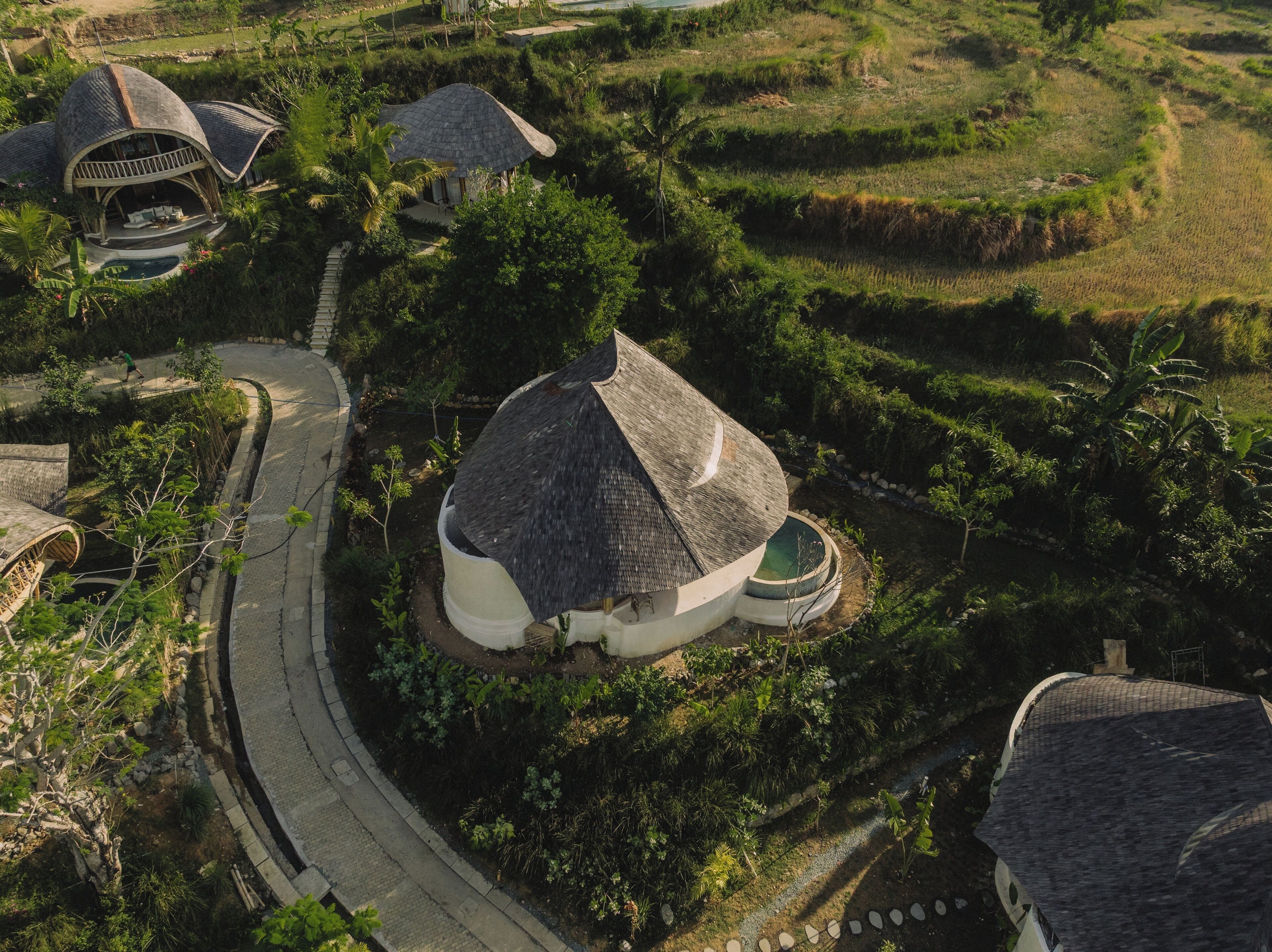 A rural setting with terraced fields and traditional thatched-roof houses.