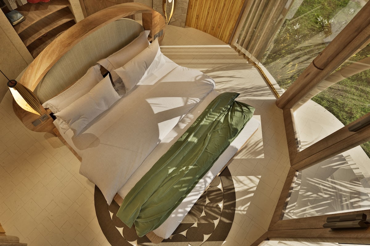 A bed with a wooden frame, white bedding, and a green cover.