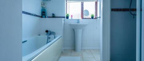 A bathroom with a bathtub, a sink, and a shower.