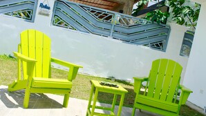 A bright outdoor seating area with a table and two chairs.