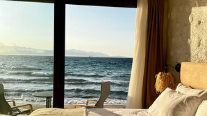 A room with a bed, a chair, and a view of the sea. - Aporte Hotel  (Çeşme)