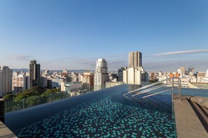 A rooftop infinity pool with a cityscape view, surrounded by high-rise buildings. - London SP Residences (Sao Paulo)