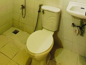 WC, jossa on vesisäiliö, suihkuletku ja pesuallas.