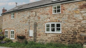 A stone building with multiple windows and a ladder.