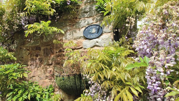A stone wall with a sign reading "Little Barn."