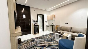 Un salon moderne avec un canapé, une table basse et un tapis à motifs.