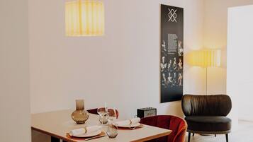 A modern dining area with a wooden table, black chairs, and a pendant light.