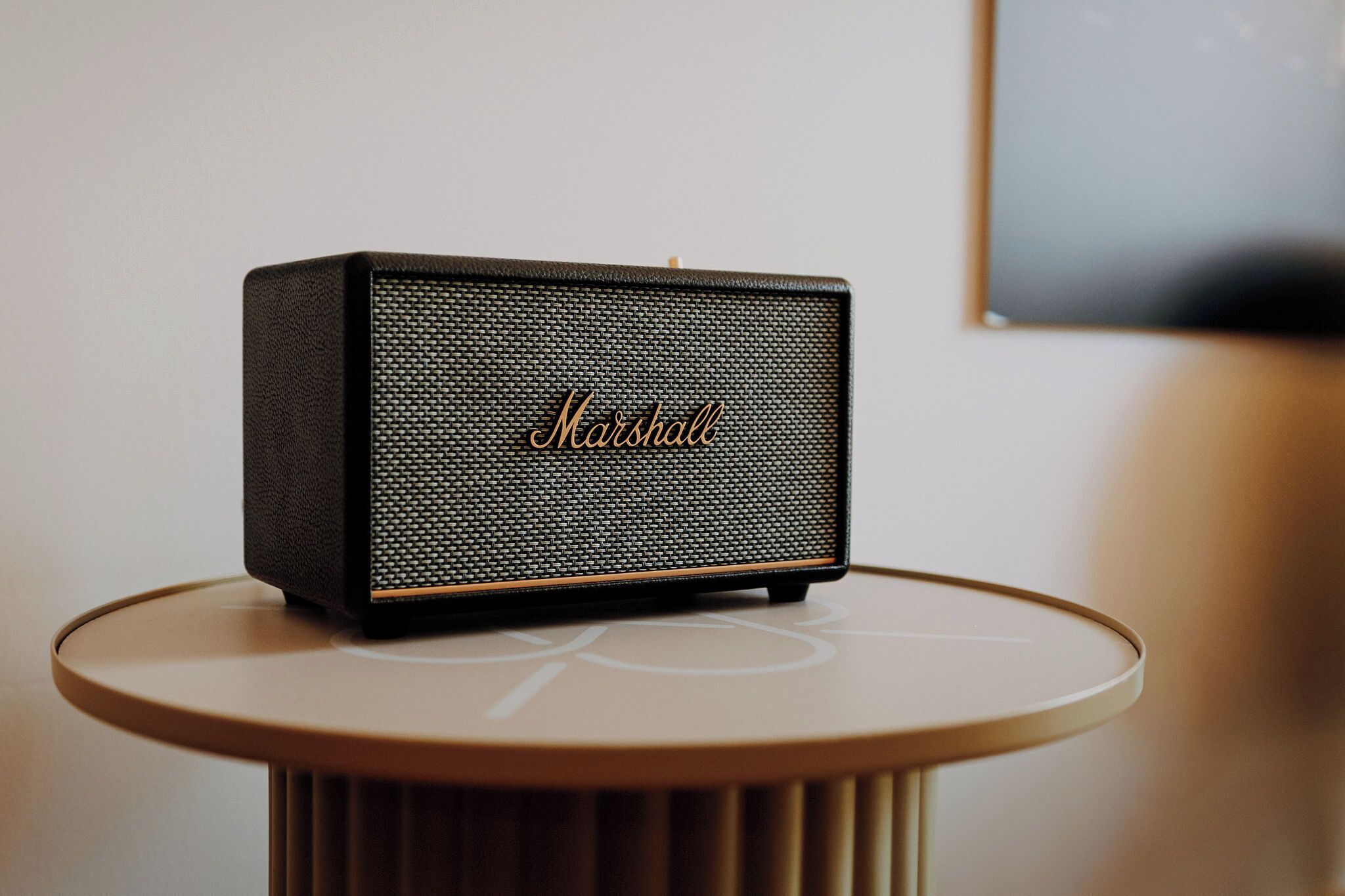 A Marshall speaker on a round table with a ribbed base.