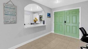 A reception area with a white reception desk, a green door, and a wall with a mermaid sign. - Sunseeker Paradise for 8! (Port Charlotte)