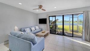 A modern living room with a sofa, coffee table, and a ceiling fan. - Sunseeker Paradise for 8! (Port Charlotte)